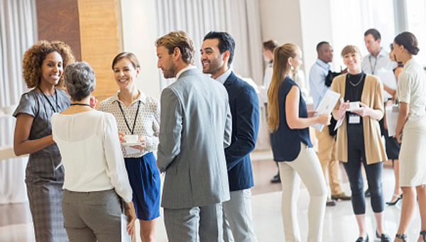 A group of people talking in a networking event. A group of people talking in a networking event.