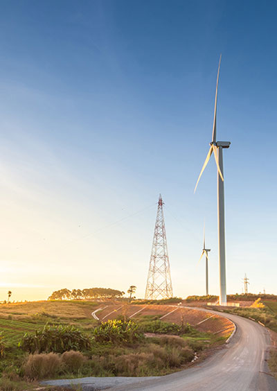 Wind tower behind solar panels