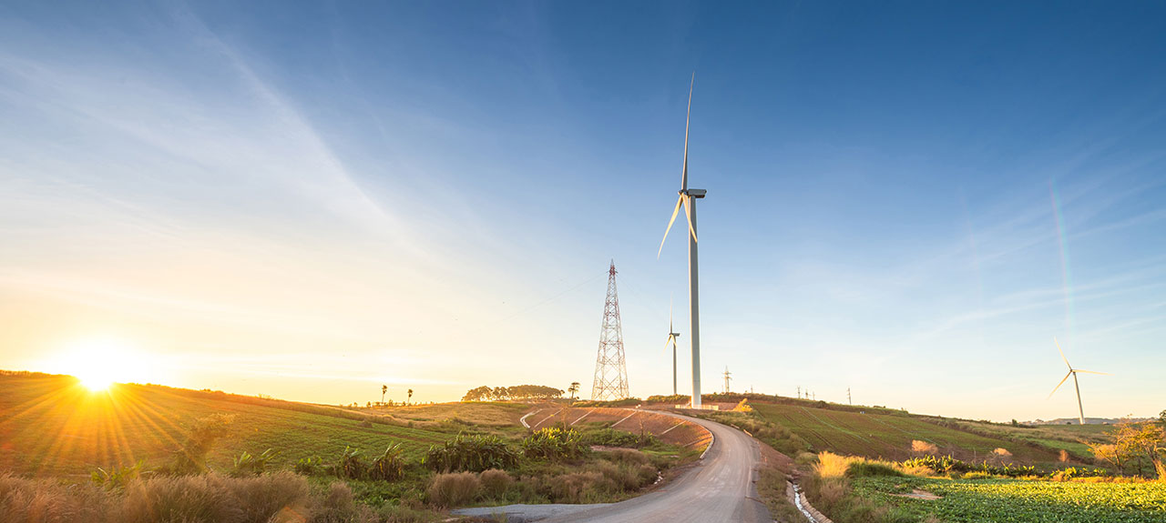 Wind tower behind solar panels