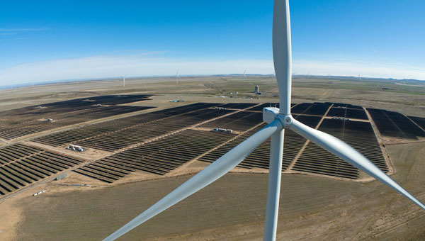 Aerial view of land with wind turbines and solar panels