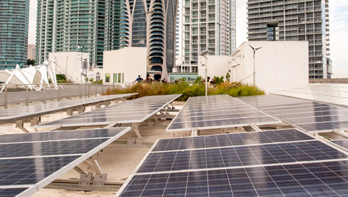 Solar panels in a city with skyscrapers in the background