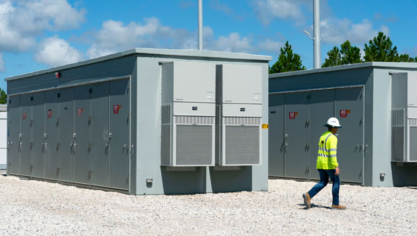 Employee in hard hat walking outside at a storage facility