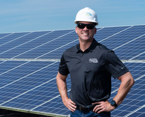 NextEra Energy Resources employee leaning against solar panel NextEra Energy Resources employee leaning against solar panel