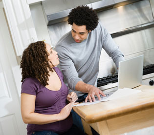Couple discussing documents over a computer