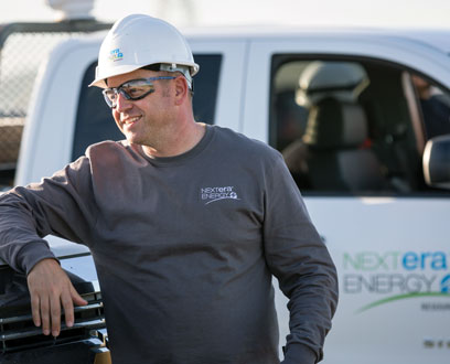NextEra Energy Resources employee leaning against solar panel