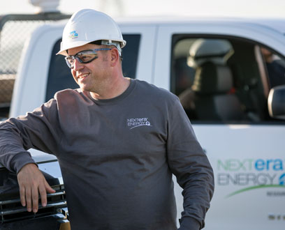 NextEra Energy Resources employee leaning against solar panel NextEra Energy Resources employee leaning against solar panel