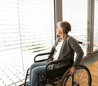 Woman on wheelchair looking out at window