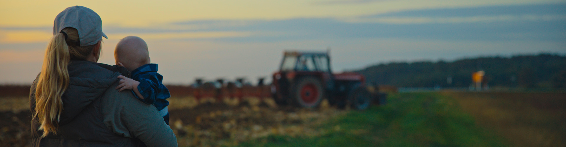 Landowner with her child looking at a tractor