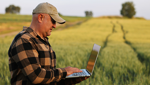 Landowner using a laptop while on his farm
