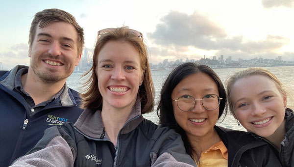 NextEra Mobility team members in front of a waterfront view of a city skyline
