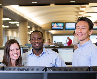 Three employees in front of computer monitor Three employees in front of computer monitor