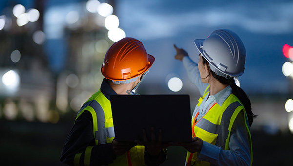 Energy workers pointing at an energy facility