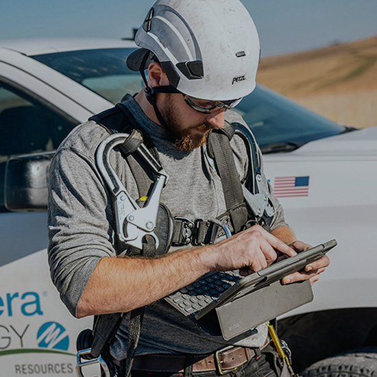 Wind technician reviewing information on a tablet computer