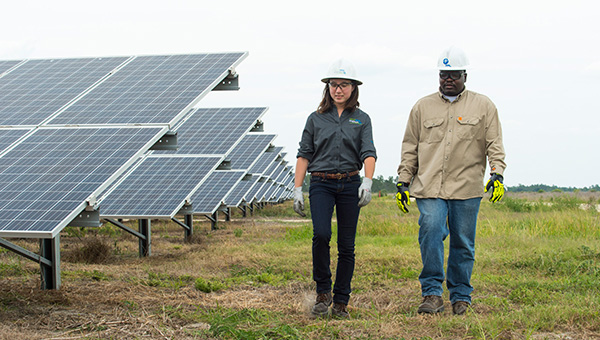Two employees walking through a solar energy facility