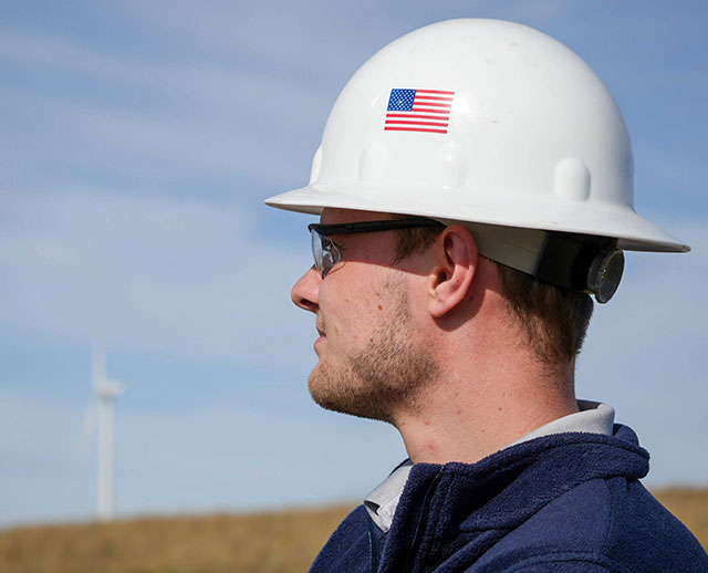 Man wearing a hard hat with an American flag on it 