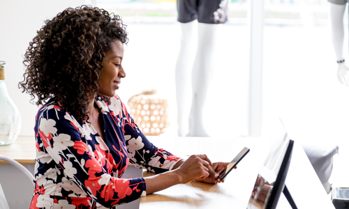 Woman at a desk on her phone.