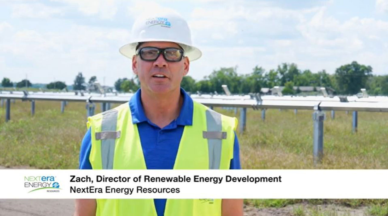 NextEra employee wearing a hard hat and bright yellow vest
