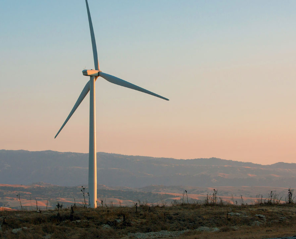 Wind turbine in an open field during sunset Wind turbine in an open field during sunset