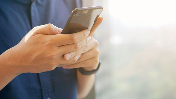 man's hands holding a smart phone