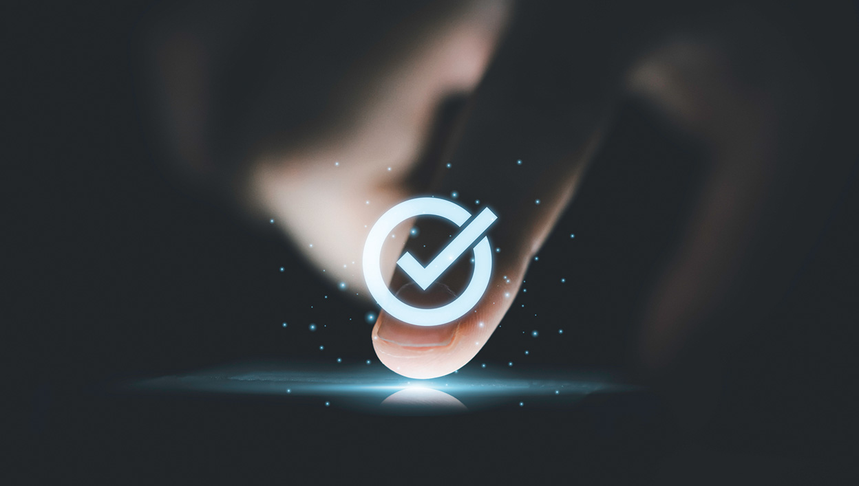 Hand touching a screen with a check mark overlay