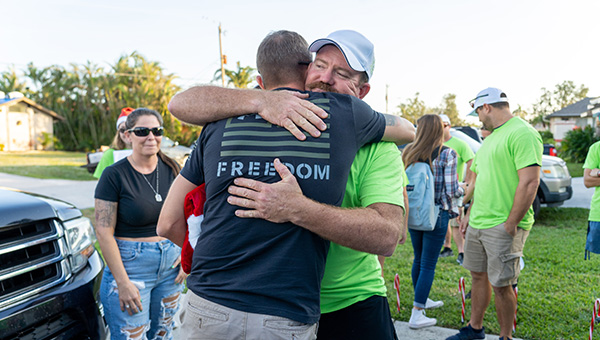 Community engagement with veteran hugging an employee