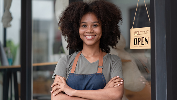 Young entrepreneur standing in front of an open sign