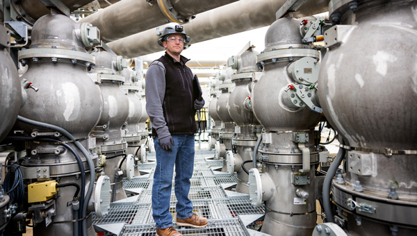 Technician inspecting piping systems at a power plant for reliability.