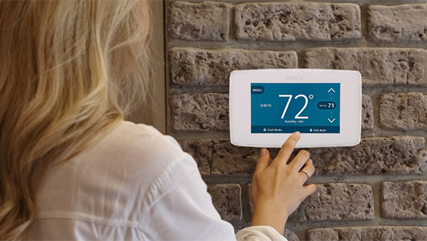 Lady adjusting the thermostat in her home