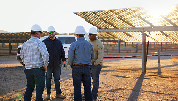 Four men talking at a solar energy site
