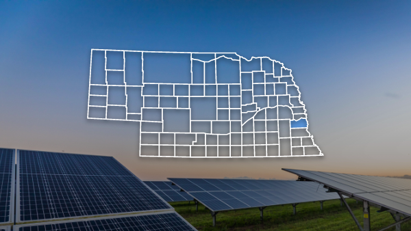 Nebraska map outline with county highlighted with an image of solar panels in the background