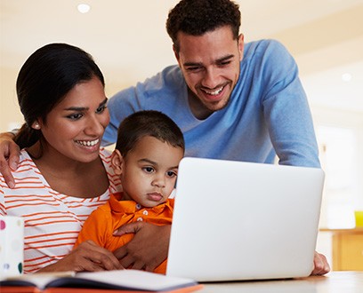 family looking at laptop at home